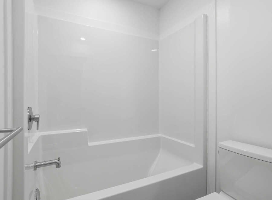 This pristine bathroom features a modern, all-white design, creating a clean and spacious feel.