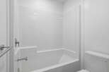 This pristine bathroom features a modern, all-white design, creating a clean and spacious feel.