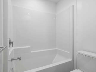 This pristine bathroom features a modern, all-white design, creating a clean and spacious feel.