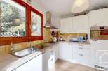 This charming kitchen features a bright and airy design with ample natural light streaming in from the large windows.