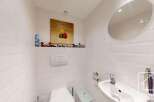 This charming bathroom features a modern design with white subway tiles and a sleek, round mirror.
