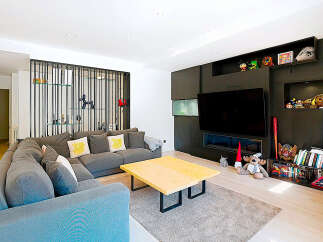 This stunning living room boasts a modern design with a cozy sectional sofa, perfect for relaxing and entertaining.