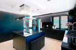This modern kitchen boasts sleek black cabinetry and a stylish island with a built-in cooktop.