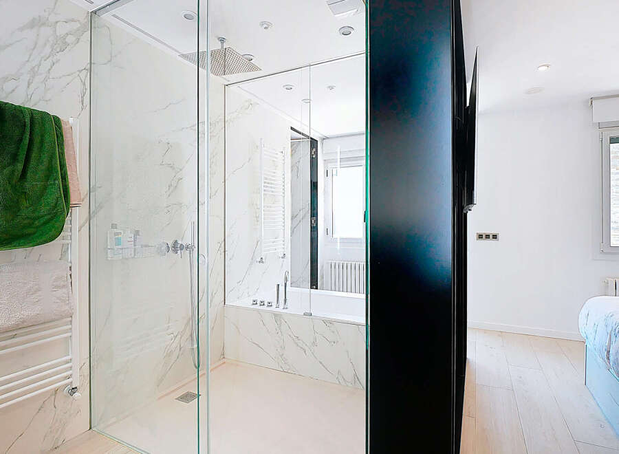 Step into luxury with this stunning bathroom featuring a sleek glass shower enclosure and elegant marble accents.