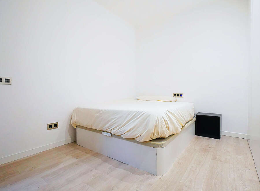 Discover this cozy bedroom featuring a comfortable bed and a minimalist design.
