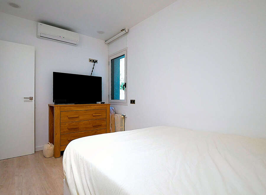 This modern bedroom features a sleek design with a comfortable bed and a stylish wooden dresser.