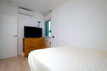 This modern bedroom features a sleek design with a comfortable bed and a stylish wooden dresser.