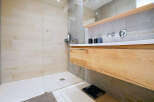 Step into a modern bathroom oasis, featuring a sleek walk-in shower with light-colored wood-look tiles.