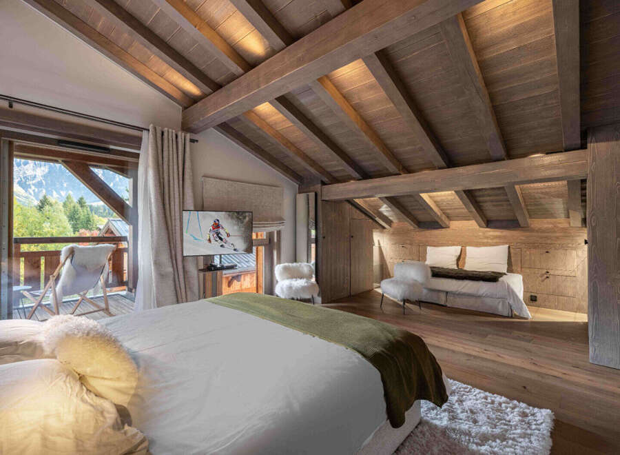 Experience luxury living in this stunning bedroom with a breathtaking mountain view.