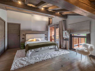 Experience luxury living in this stunning bedroom, featuring a cozy bed with a plush rug.