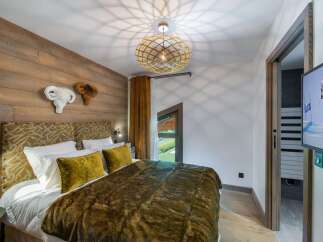 Experience luxury in this exquisite bedroom featuring a cozy bed adorned with plush pillows and a warm, inviting blanket.