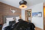Experience luxury in this stunning bedroom featuring a unique wood-paneled wall and a stylish headboard.