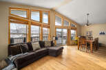 This stunning living space boasts an abundance of natural light, thanks to the expansive windows that frame breathtaking mountain views.