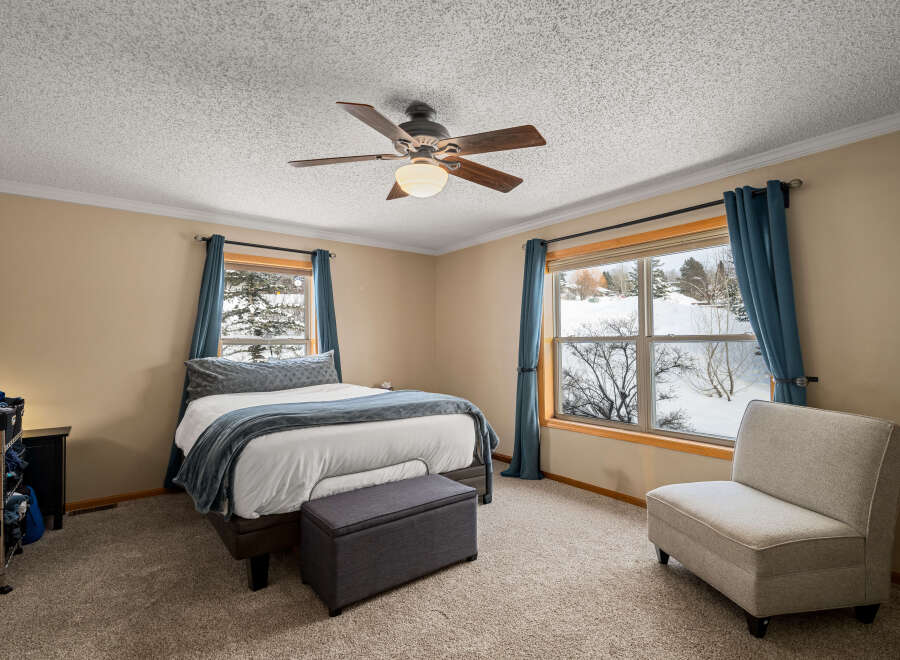 This inviting bedroom features a cozy atmosphere with a comfortable bed and a stylish accent chair.