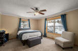 This inviting bedroom features a cozy atmosphere with a comfortable bed and a stylish accent chair.