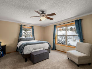 This inviting bedroom features a cozy atmosphere with a comfortable bed and a stylish accent chair.