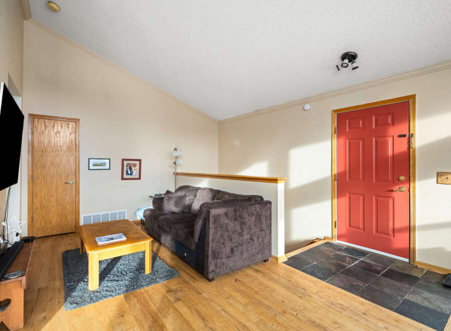 Step into this inviting living space, featuring a cozy brown sofa and a charming wooden coffee table.