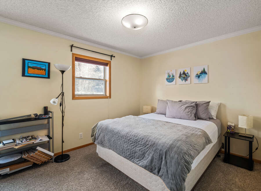 This cozy bedroom features a comfortable bed with a stylish gray comforter and pillows, perfect for a relaxing retreat.