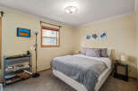 This cozy bedroom features a comfortable bed with a stylish gray comforter and pillows, perfect for a relaxing retreat.