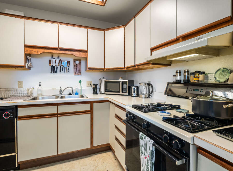 This charming kitchen boasts ample counter space and cabinetry, perfect for culinary enthusiasts.