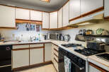 This charming kitchen boasts ample counter space and cabinetry, perfect for culinary enthusiasts.