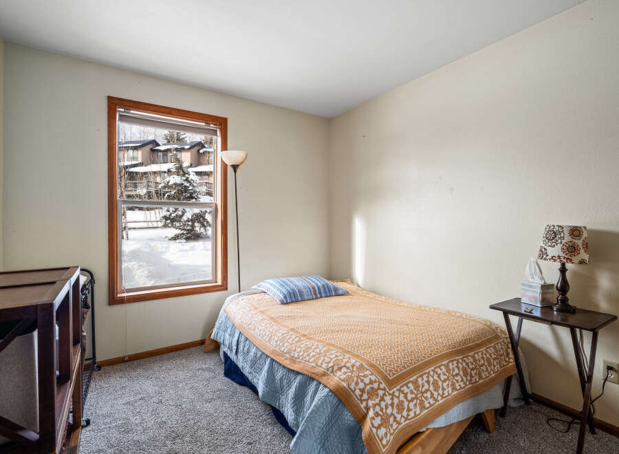 This cozy bedroom offers a tranquil retreat with its inviting ambiance and natural light.