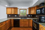 This charming kitchen features warm oak cabinetry complemented by elegant granite countertops.