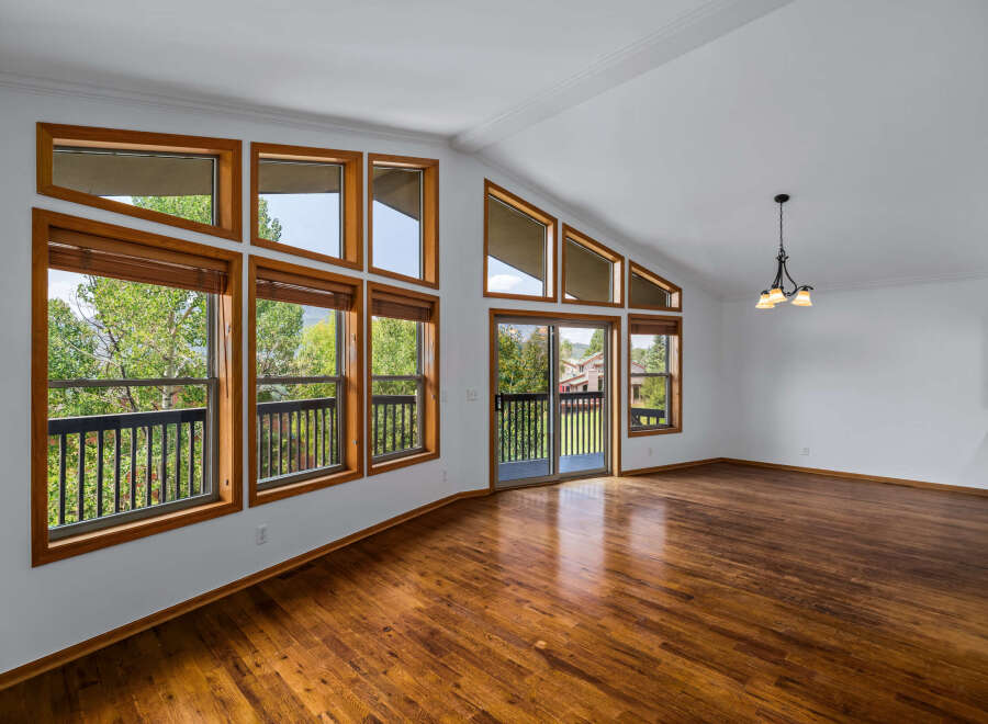 Experience breathtaking mountain views from this stunning living room, featuring a wall of large windows that flood the space with natural light.