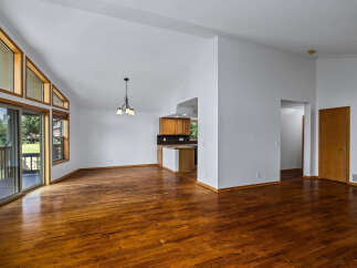 Experience spacious living in this open-concept home featuring a vaulted ceiling and abundant natural light from large windows.