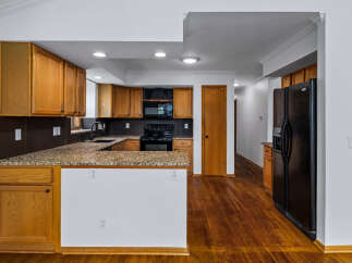 Discover this charming kitchen featuring warm oak cabinetry and granite countertops, perfect for any home chef.