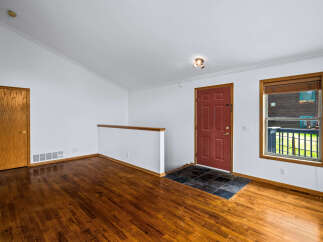 Step into this inviting entryway featuring gleaming hardwood floors that extend throughout the space.