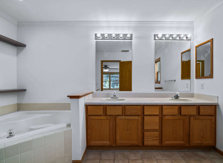 This spacious bathroom features a large soaking tub and a double vanity with ample counter space.