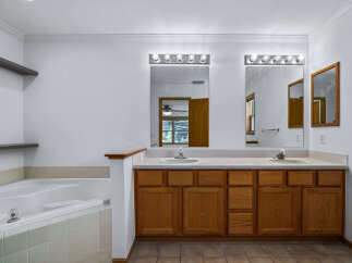 This spacious bathroom features a large soaking tub and a double vanity with ample counter space.