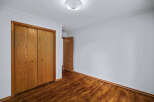 Step into this inviting room featuring a spacious closet with beautiful wooden doors, perfect for ample storage.