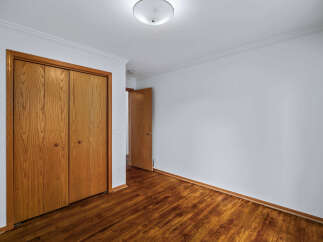 Step into this inviting room featuring a spacious closet with beautiful wooden doors, perfect for ample storage.