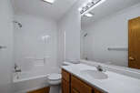 This bright and clean bathroom features a spacious white bathtub and shower combo, perfect for relaxing after a long day.