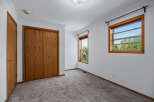 This bedroom features a spacious closet with natural wood doors and a matching interior door.