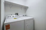 This laundry room features a white Whirlpool top-load washing machine and a matching dryer.