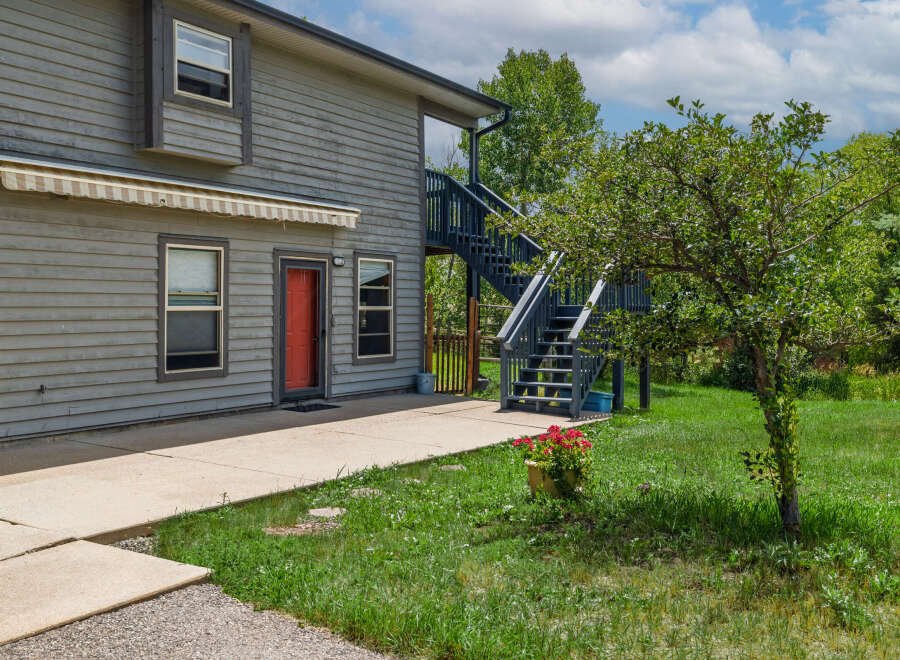 Discover this charming property featuring a welcoming red door and an exterior awning for added comfort.