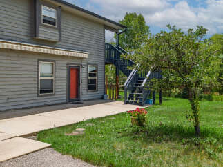 Discover this charming property featuring a welcoming red door and an exterior awning for added comfort.