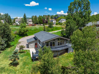 Nestled amidst lush greenery and mature trees, this charming home offers a serene mountain retreat.