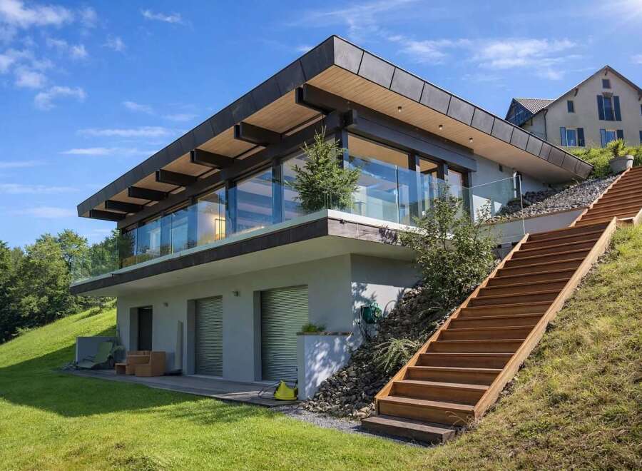 This stunning modern home boasts a sleek design with expansive glass windows, offering breathtaking views and abundant natural light.