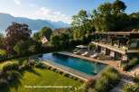 Experience luxury living with this stunning property featuring an infinity pool overlooking a serene lake and majestic mountains.