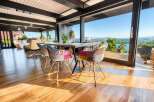 Experience breathtaking panoramic views from this stunning dining area, featuring floor-to-ceiling windows that seamlessly blend indoor and outdoor living.