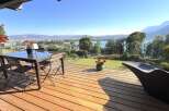 Enjoy breathtaking panoramic views from this stunning modern home's expansive deck, perfect for entertaining or relaxing.