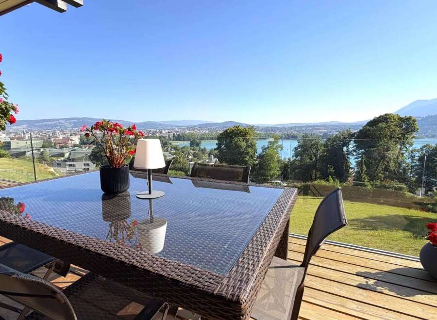 Enjoy breathtaking panoramic views from this stunning property's balcony, featuring a modern outdoor dining set perfect for al fresco meals.