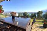Enjoy breathtaking panoramic views from this stunning property's balcony, featuring a modern outdoor dining set perfect for al fresco meals.