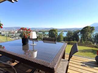 Enjoy breathtaking panoramic views from this stunning property's balcony, featuring a modern outdoor dining set perfect for al fresco meals.