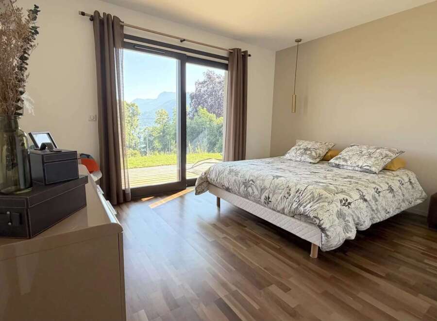 Experience breathtaking mountain and lake views from this serene bedroom, featuring a comfortable queen-size bed with a nature-inspired duvet.