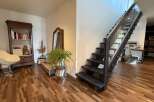 Experience modern living with this stunning staircase featuring sleek glass railings and dark wood treads, seamlessly connecting to a beautifully appointed entryway.
